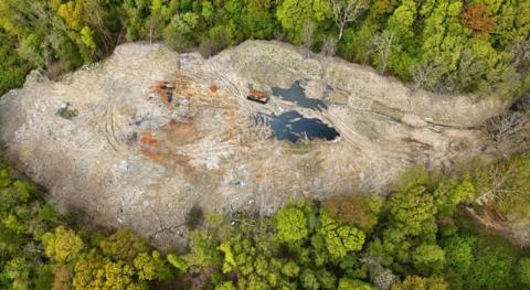 An aerial shot of Hoads Wood which shows the extend of fly tipping amid a green woodland.