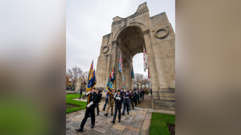 Soldiers and veterans holding flags in front of the Arch of Remembrance in Victoria Park, Leicester, for the Remembrance Sunday service on 9 November 2024.