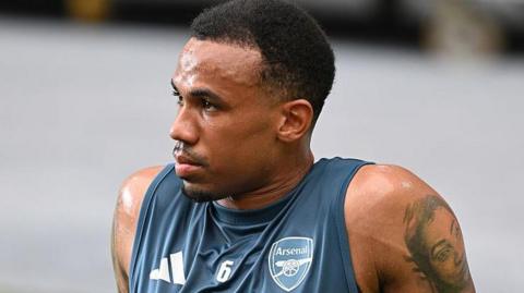 Gabriel looks into the distance, wearing an Arsenal training vest