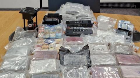 A haul of cocaine wrapped in clear plastic bags, along with bags of Euro notes and money counting machines which were seized by gardaí in Dublin. 