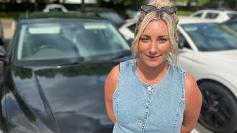 Sophie Rose standing in front of her car