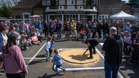A player takes a shot as he competes in the World Marbles Championship outside the Greyhound Pub.
