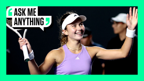 Iva Jovic smiles and holds her racquet in the air