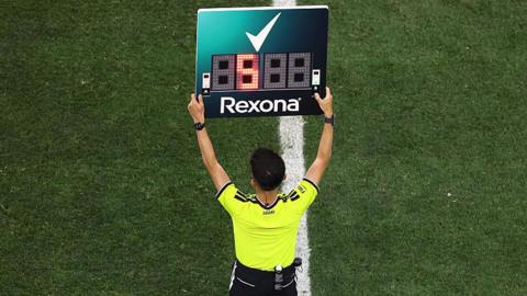 The fourth official holds up the substitution board during the Fifa World Cup match between Iran and New Zealand