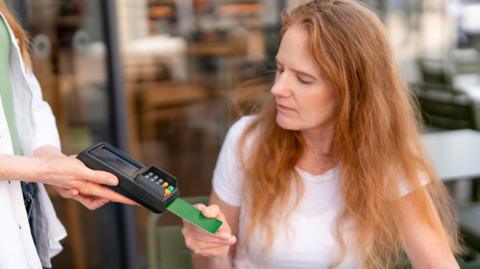 Woman pays via a card on a terminal