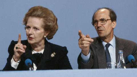 Margaret Thatcher sitting next to Norman Tebbit