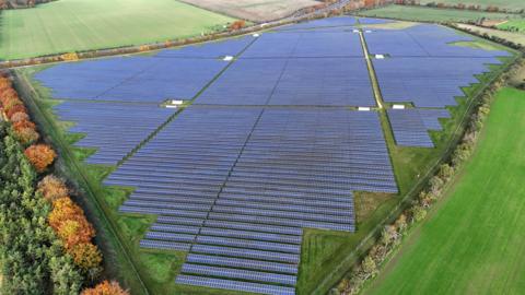 A drone picture of a large solar farm in the countryside.