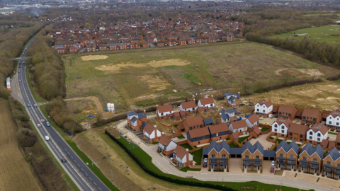 An aerial view from 2023 shows some of the new houses in Chilmington Green. Dozens of houses can be seen.