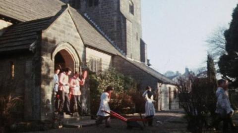 The Plough Stotters walk out of a church