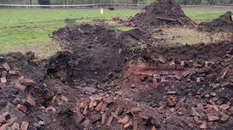 Exposed brickwork after an area of a field was dug up 