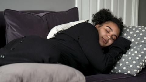 Pregnant woman snoozing on sofa