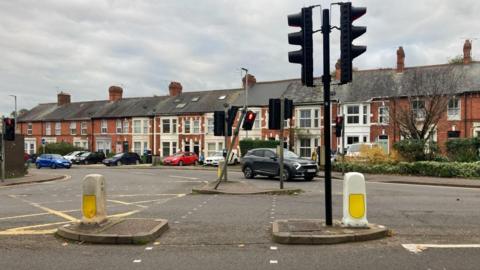 A picture of Hurdle Way at the junction of Mansfield Road.  The picture shows traffic lights and a car at the junction.