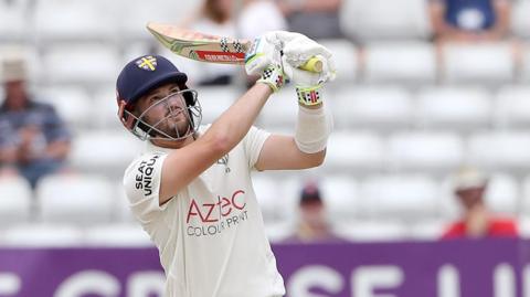 Ollie Robinson watches one of his shots as he makes 198 against Essex.