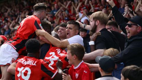 Morecambe players and fans celebrate goal