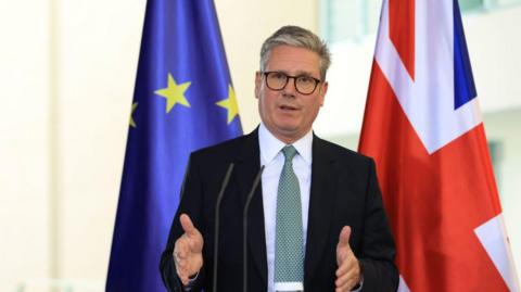 Keir Starmer, UK prime minister, during a news conference standing in front of the EU and Union Jack flags.