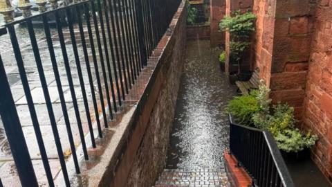 Steps down to the basement of Michelangelo are covered in brown water.