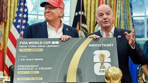 US President Donald Trump and Uefa president Gianni Infantino pose with a giant mock World Cup ticket