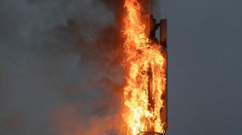 A metal mast with a large plume of fire.