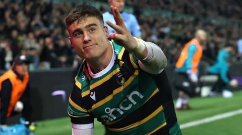Northampton wing Tommy Freeman holds up four fingers after scoring his final try against Saracens