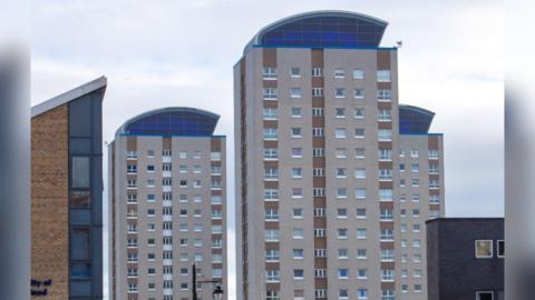 Lambton, Londonderry, and Lumley Towers in Sunderland's East End. There are three hi-rise blocks of flats that are beige-coloured with brown striped panels and a roof section that is blue-tinted. 