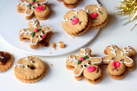 Plate of home-made biscuits in different shapes, iced and decorated to look like reindeer.
