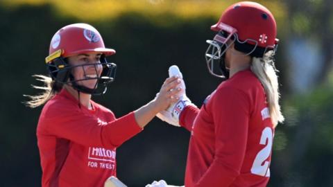 Fi Morris and Ellie Threlkeld slap hands after Lancashire beat Surrey in the One-Day Cup