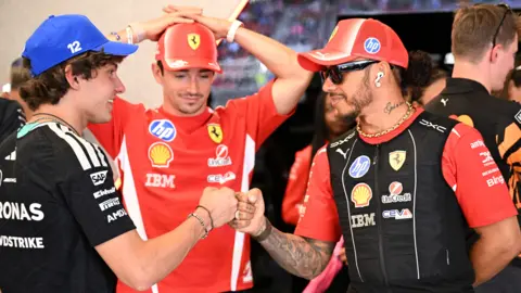 Mercedes' Kimi Antonelli and Ferrari's Lewis Hamilton bump fists with Charles Leclerc stood in the background before the Barcelona-Catalunya Grand Prix