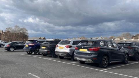 A row of cars parked in a car park