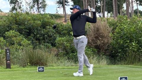 Rob Wheeler holds a pose after playing his tee shot 