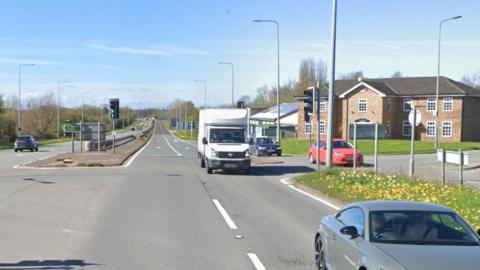 Google streetview of junction with vehicles passing by a two-storey property.