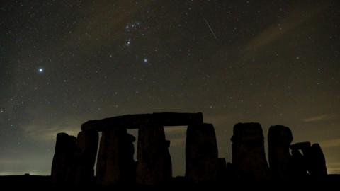 A meteor streaks in the skies above Stonehenge