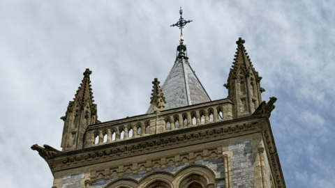 A large stone church with a tall central spire surrounded by turrets.