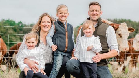 Lizzie and Steven Walker with their three children in front of their cattle