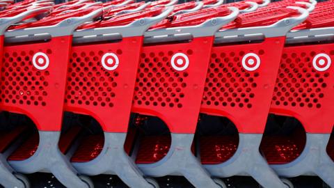 Five red shopping carts with Target logos are lined up outside.