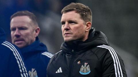 Eddie Howe in black Newcastle United club coat with three thin white stripes on sleeve