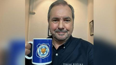 TV star holding a mug