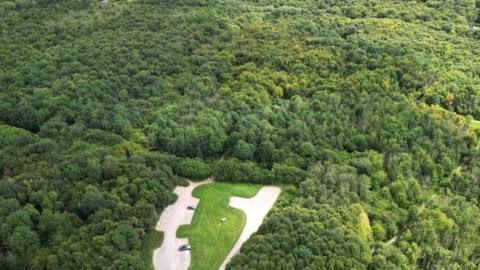 Aerial image of Nightingale Wood with a small car park surrounded by thick covering of trees