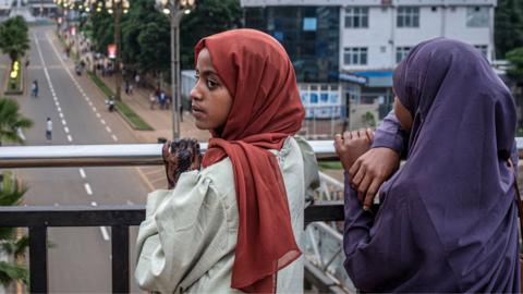 Two young women looking over a bridge on to a newly built roads near a monument in Addis Ababa - May 2026