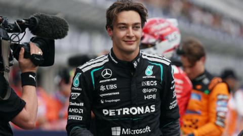 Mercedes' George Russell smiles after getting out of his car and taking pole position for the Australian Grand Prix