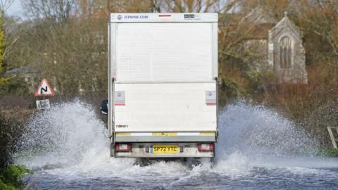 Van driving through flooded road