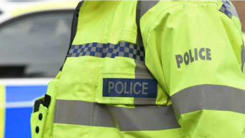 A close up of a police officer wearing yellow uniform 