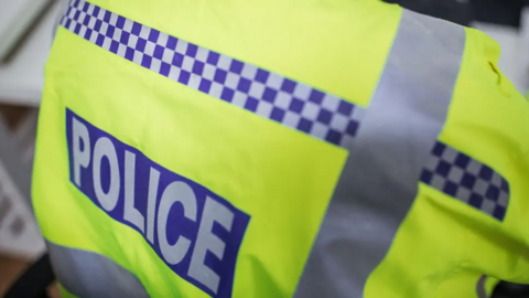 A general view of the back of a police's hi-vis jacket.