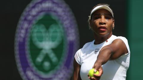 Serena Williams prepares to toss a tennis ball in practice at Wimbledon