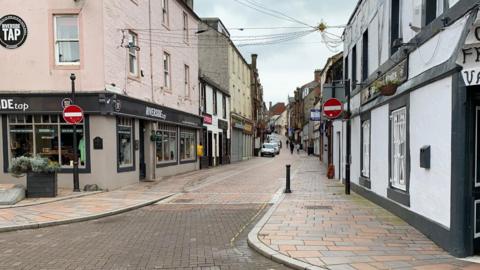 A picture of Friars Vennel a narrow road wending its way through Dumfries with a paved roadway
