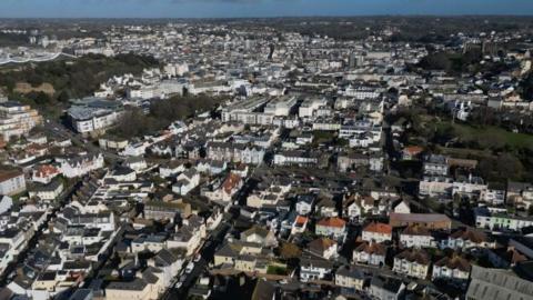 Drone shot of housing and office buildings in St Helier, Jersey. A playing field is on the right hand side of the photo.