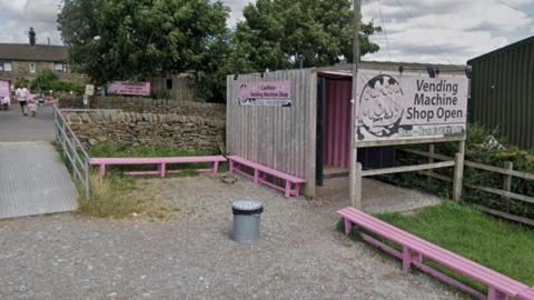 General view of the Our Cow Molly ice cream shop, with farm buildings in the background.