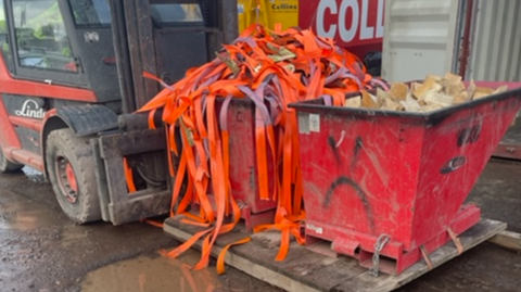 The forklift truck involved in the incident with two bins filled with waste on a pallet