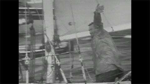 Robin Knox-Johnston waves as he sails into Falmouth Harbour.