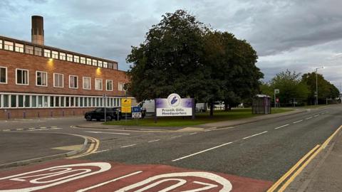 An exterior image of Highland Council's headquarters in Glenurquhart Road in Inverness. It is a red-brick building with trees in front of it.