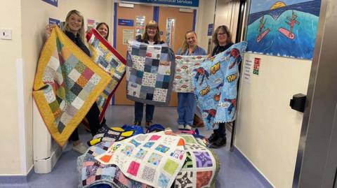 Nurses carrying quilts